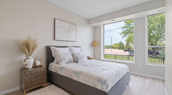 Bedroom at The Townline Apartments with large windows, neutral finishes, and natural light.