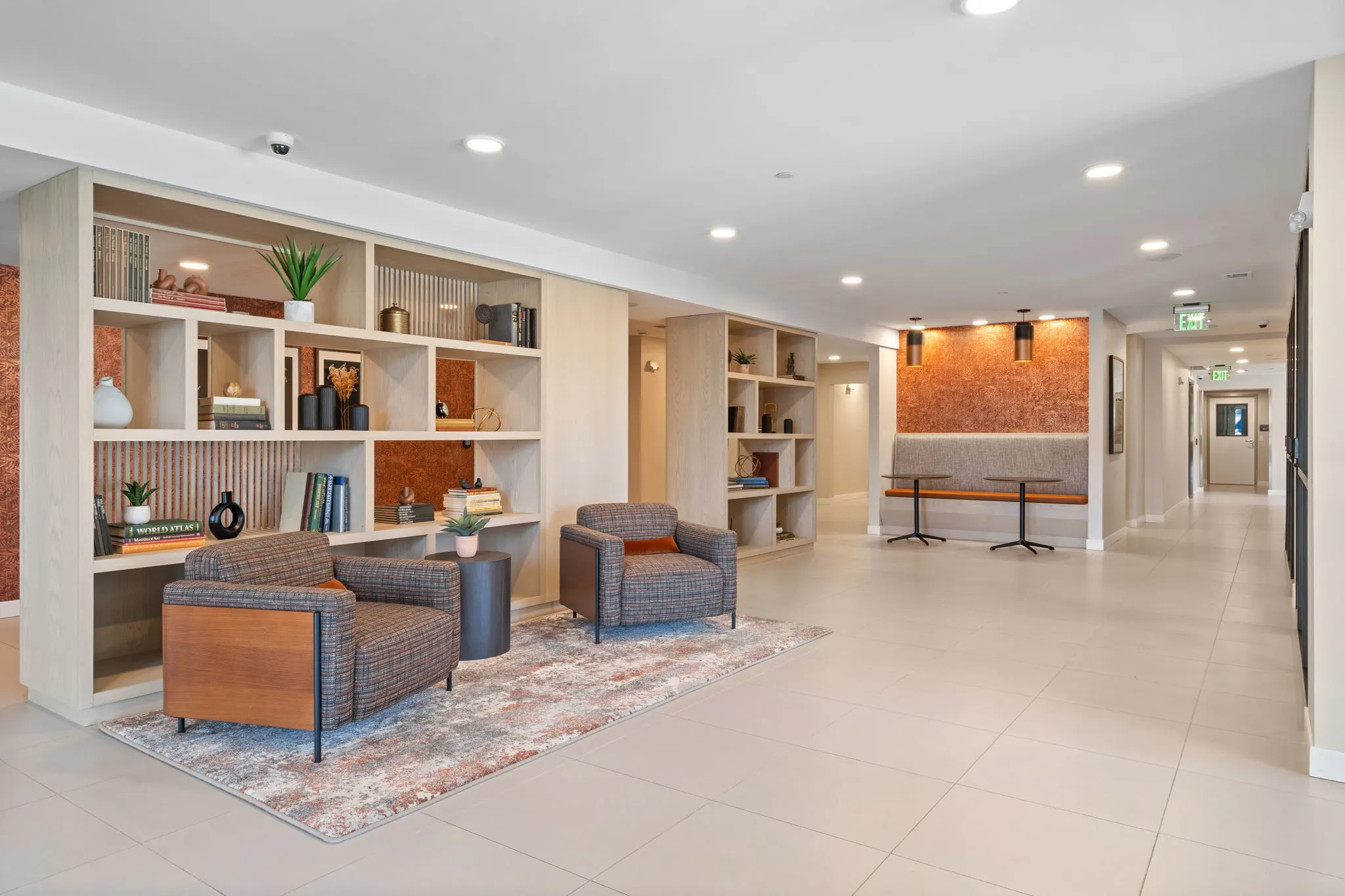 Resident lounge hallway at The Townline Apartments with built-in shelving, accent seating, and shared gathering areas.