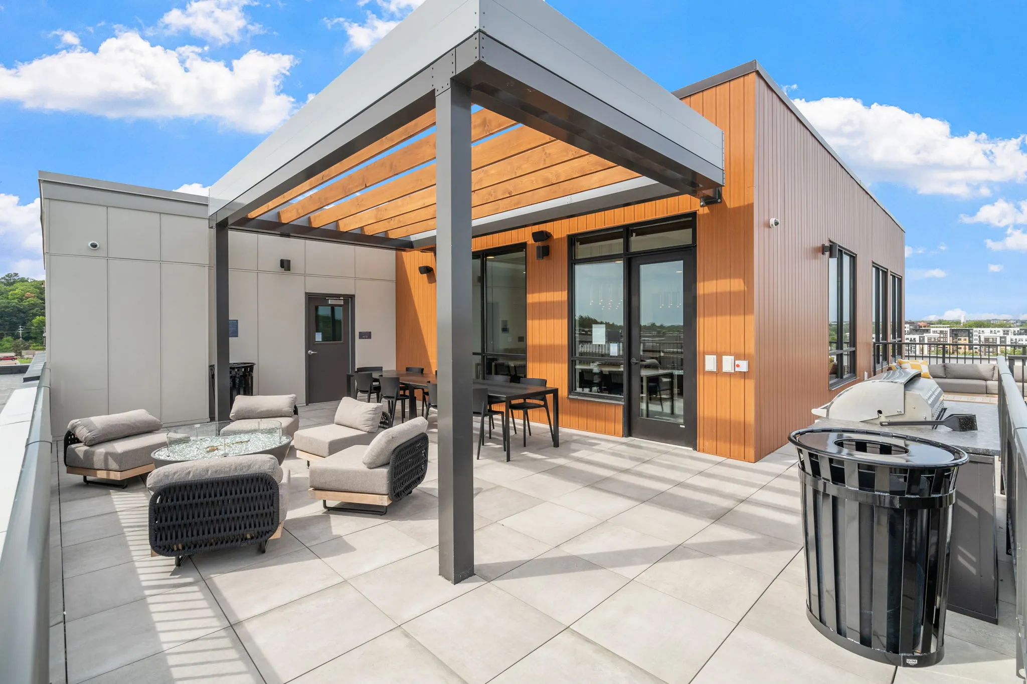 Rooftop amenity deck at The Townline Apartments with pergola seating, lounge chairs, and outdoor gathering space.