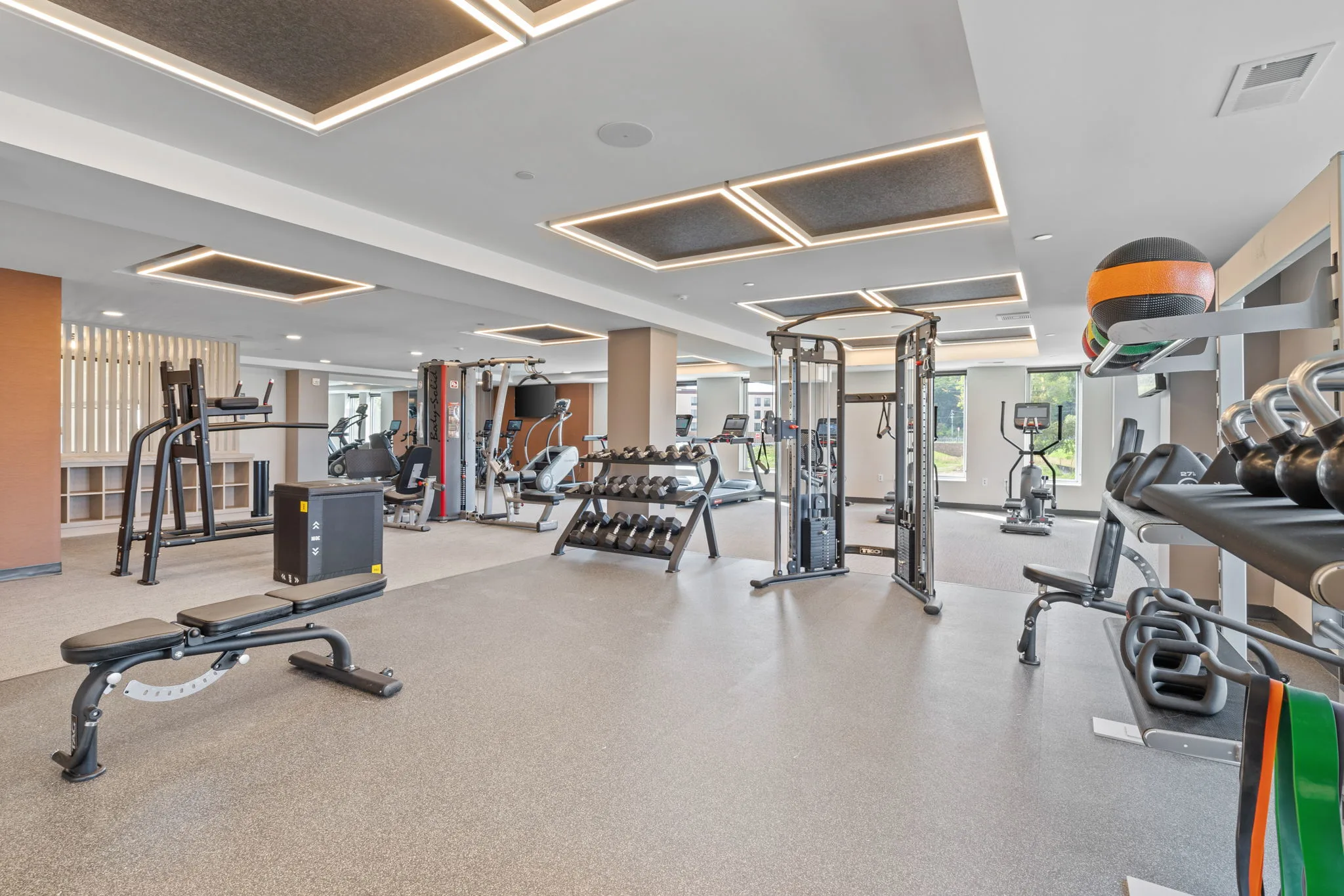 Fitness center at The Townline Apartments with strength equipment, free weights, kettlebells, and cardio machines.