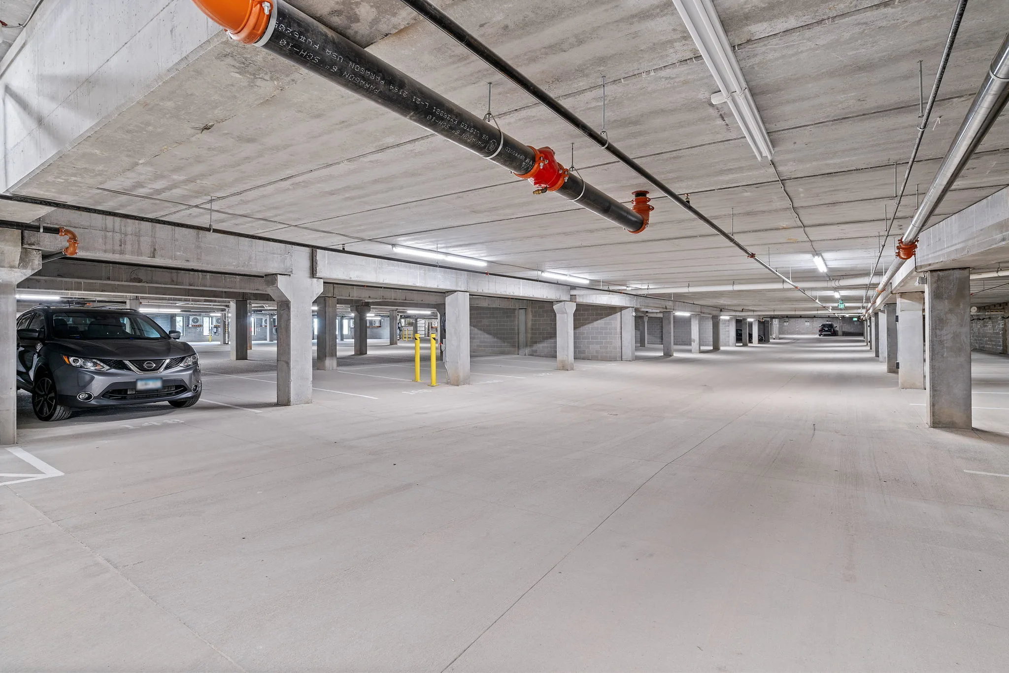 Underground parking garage at The Townline Apartments with covered resident parking and concrete support columns.