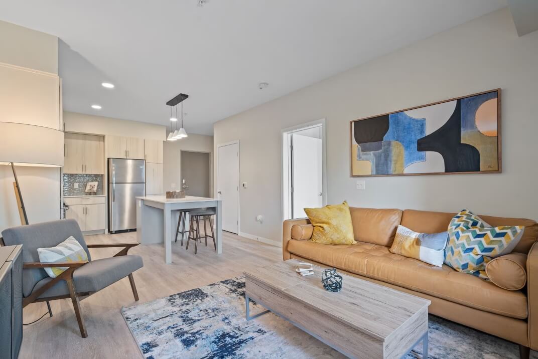 Model apartment interior at The Townline Apartments featuring an open living room, kitchen island, and modern finishes.