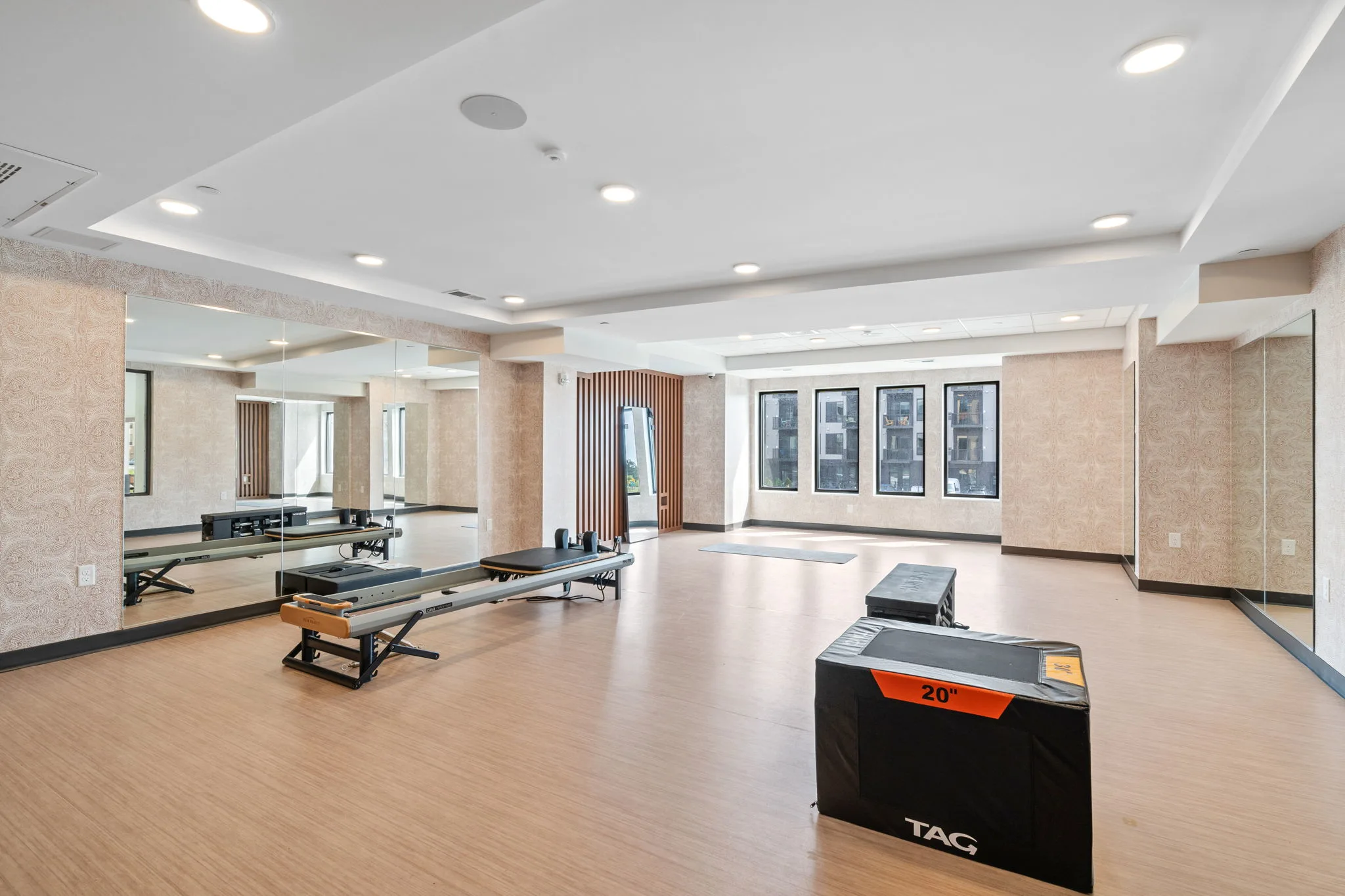 Fitness studio at The Townline Apartments with mirrored walls, open workout space, and exercise equipment.