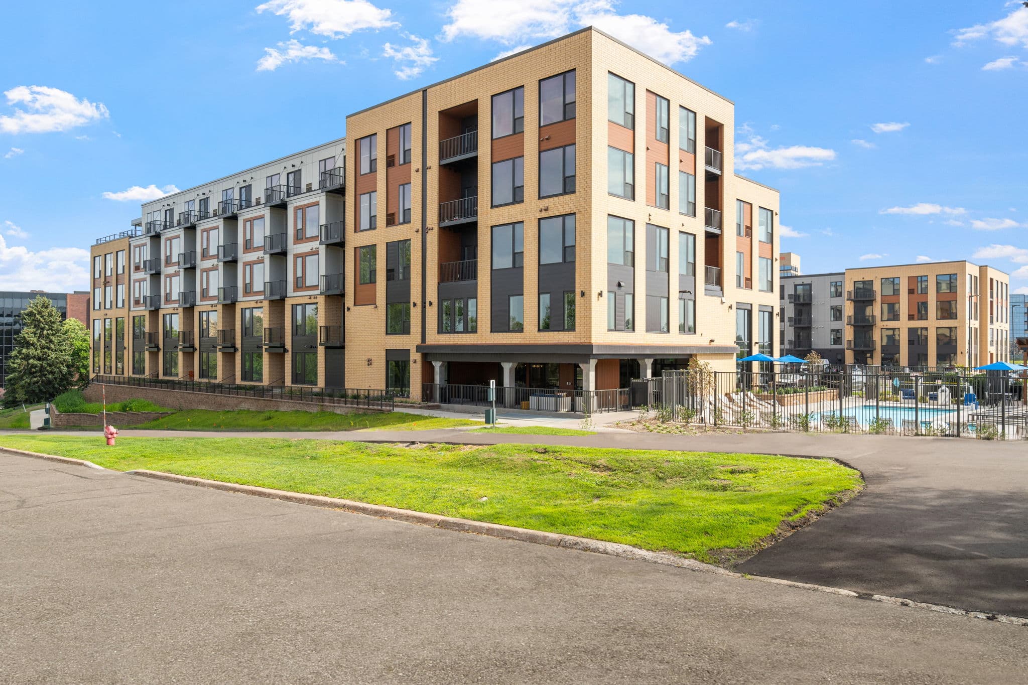 Exterior view of The Townline Apartments showing the apartment building, pool area, and surrounding grounds.