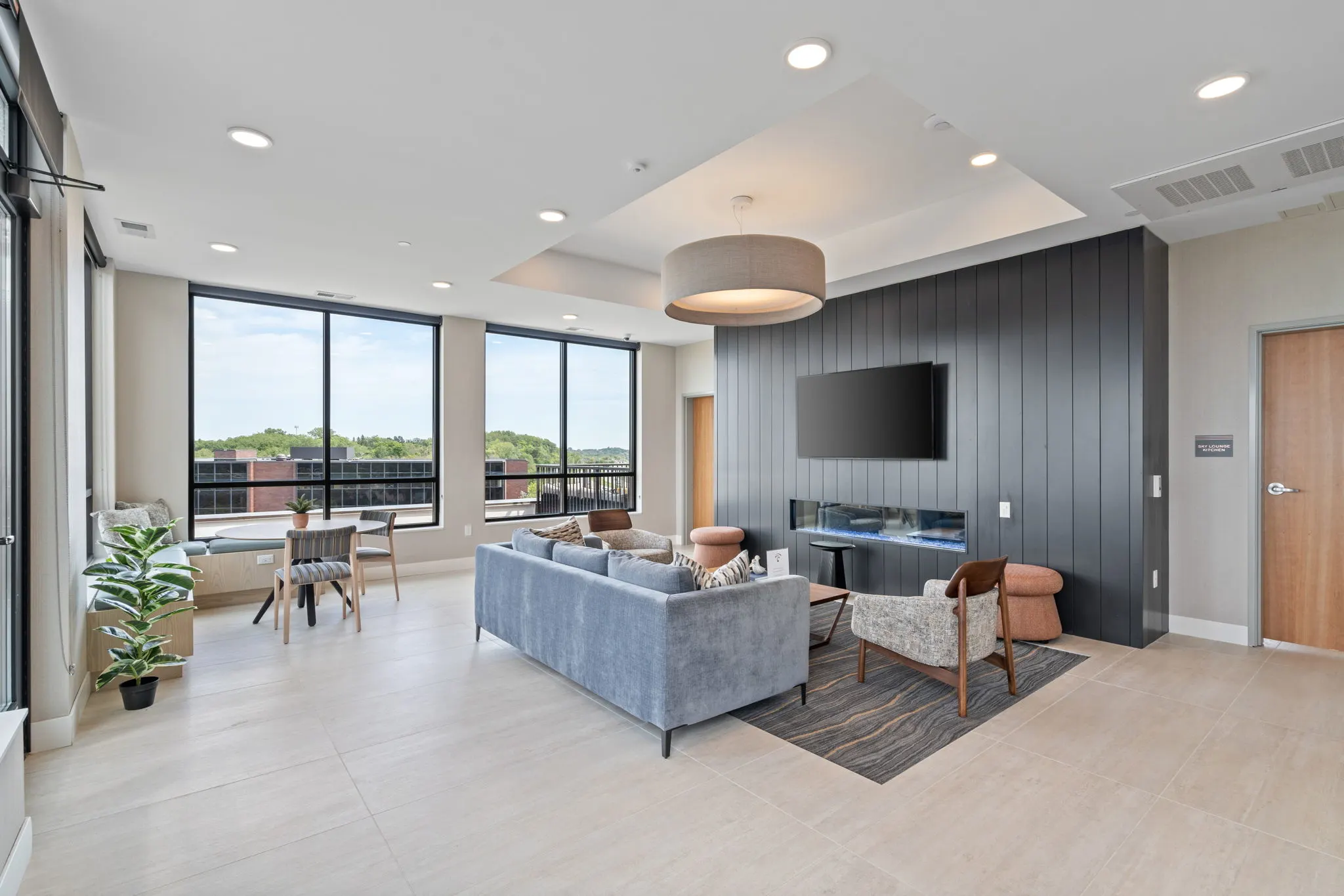 Resident lounge at The Townline Apartments with fireplace, TV, soft seating, and large windows.
