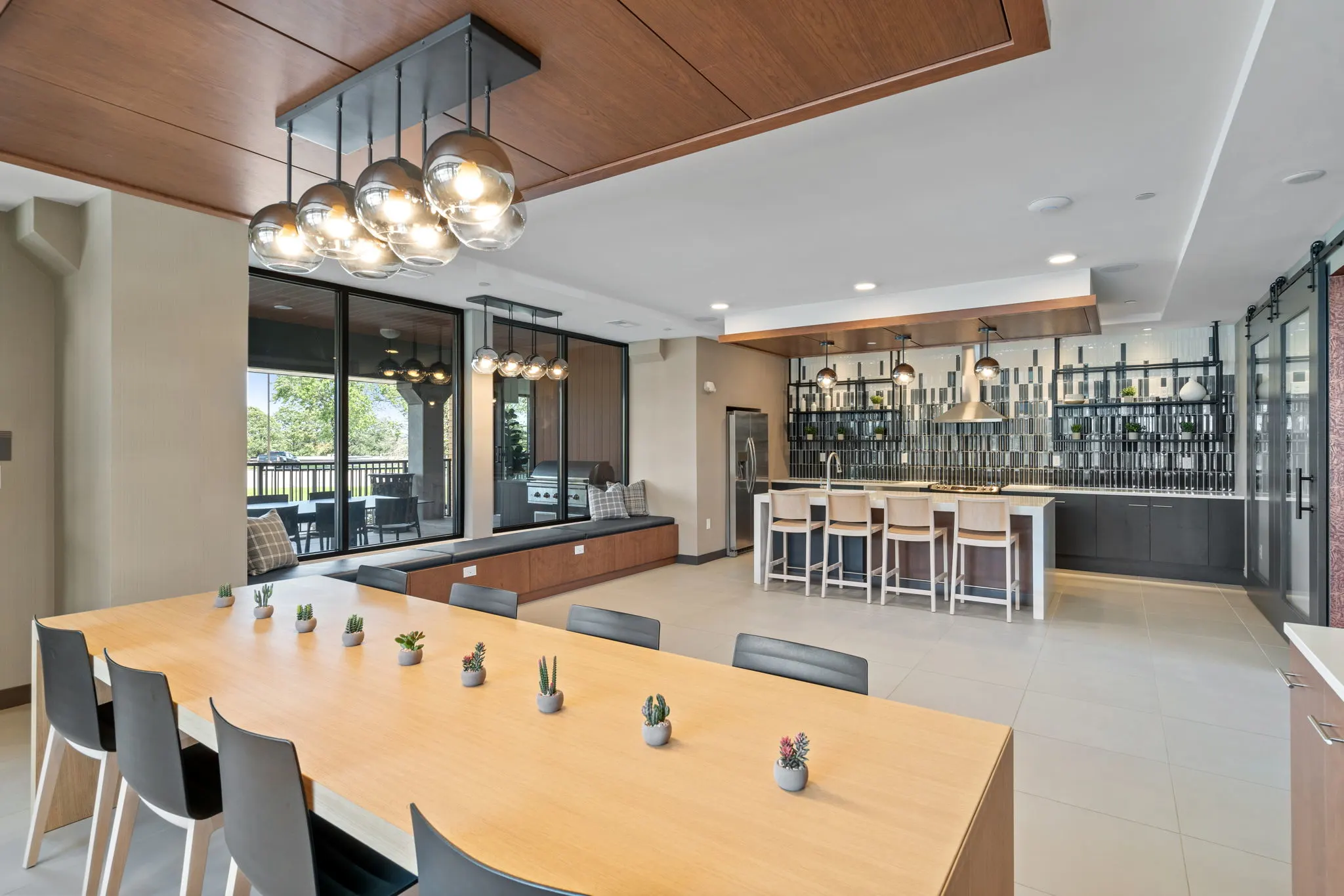 Resident gathering room at The Townline Apartments with communal table, lounge seating, and full kitchen area.