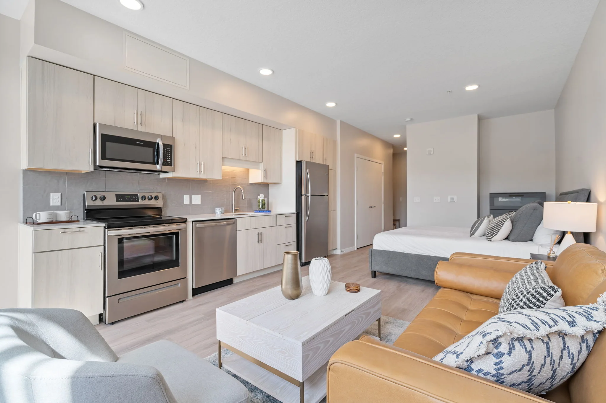 Studio apartment interior at The Townline Apartments with kitchenette, bed, seating area, and modern finishes.