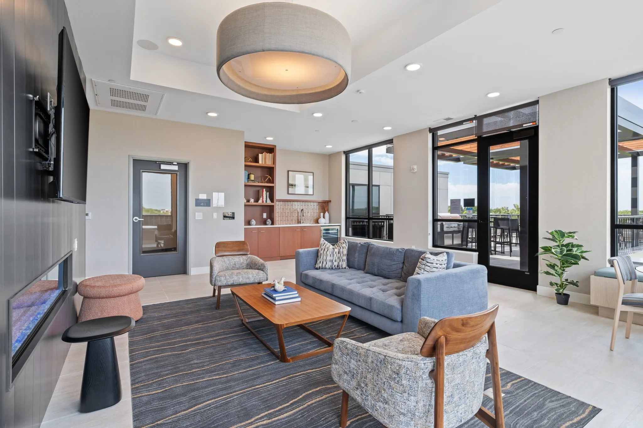 Resident lounge at The Townline Apartments with sofa seating, fireplace, and access to the outdoor terrace.